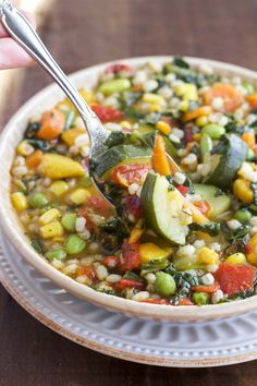 a bowl of vegetable soup with a spoon in it