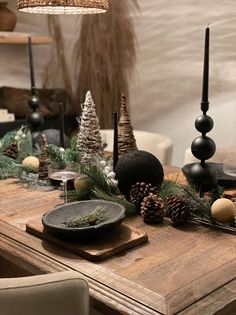 a wooden table topped with christmas decorations and candles on top of it's sides