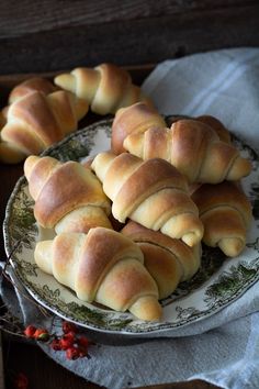 several croissants on a plate sitting on a table