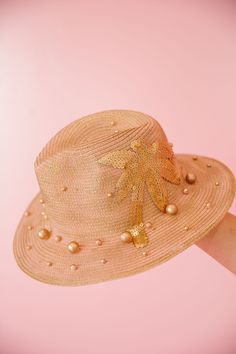 Rock the summer with THE GOLDEN PALMS SUN HAT. With a touch of rose gold and adorned with pearls, this hat will add a touch of elegance to your beach attire. The sequin palm tree patch adds a unique touch, making sure you stand out from the crowd. Bring on the sun, this hat is ready to shine! This hat is ONE OF A KIND, created by our owner Stephanie. To receive item quicker, expedited shipping is available at checkout. Luxury Palm Leaf Hats For Beach, Luxury Palm Leaf Sun Hat With Flat Brim, Luxury Palm Leaf Hats For Spring, Luxury Palm Leaf Sun Hat For Summer, Luxury Summer Sun Hat Made Of Palm Leaf, Luxury Palm Leaf Panama Hat For Beach, Luxury Curved Brim Sun Hat Made Of Palm Leaf, Luxury Palm Leaf Straw Hat For Beach, Luxury Party Sun Hat