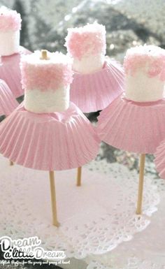 pink and white cupcakes are on sticks