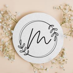 a paper plate with the letter n on it next to some baby's breath flowers