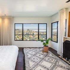 a bedroom with a large window overlooking the city