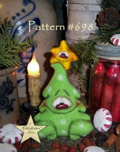 a green christmas tree sitting on top of a table next to candles and other decorations