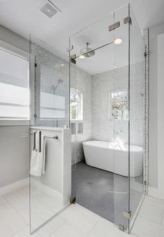 a bathroom with a glass shower door and white bathtub next to a walk in shower