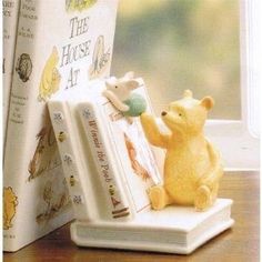 a winnie the pooh figurine next to a book