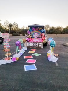 there is a car parked in the parking lot with many candy decorations on it's side