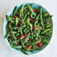 asparagus and bacon salad in a blue bowl on a marble countertop, ready to be eaten