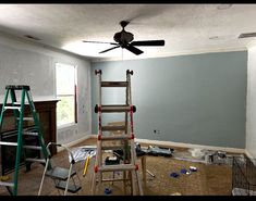 a ladder is in the middle of a room that has been painted blue and white