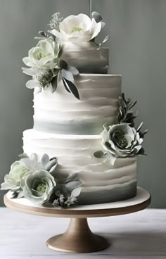 a three tiered cake with white flowers on top