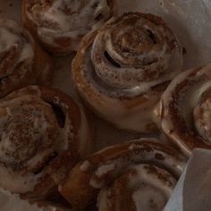 cinnamon rolls with icing sitting in a box