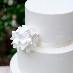 a close up of a white cake with flowers on the top and bottom tiers