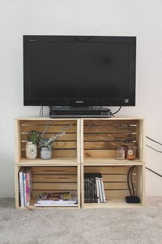 a television sitting on top of a wooden shelf