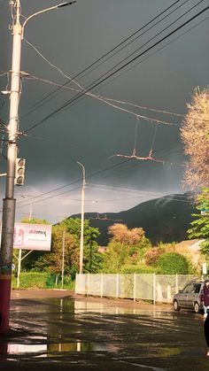 a woman walking down the street under an overcast sky with mountains in the background