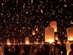 many people are flying lanterns in the sky