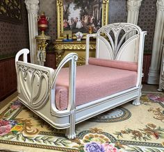 a white bed with pink sheets in a room