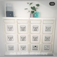 a white shelf filled with lots of drawers next to a potted plant