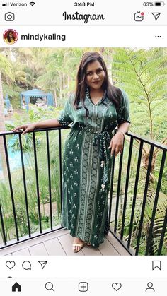 a woman in a green dress standing on a balcony