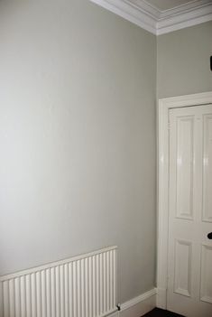 an empty room with a white door and radiator