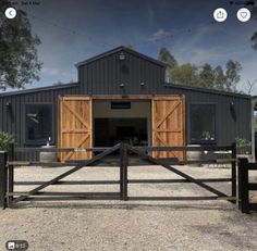 an open gate in front of a barn