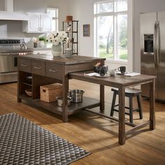 a kitchen with an island and stainless steel appliances in the center, along with two stools