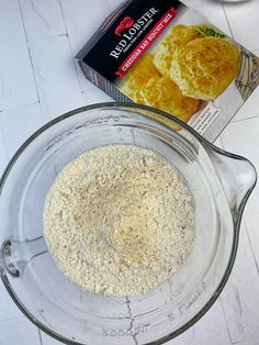 a glass bowl filled with oatmeal next to a box of breadcrumbs