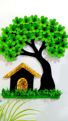 a paper cut out of a dog house under a tree with green leaves on it