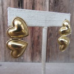 "90s gold tone chunky double heart stud statement earrings. They have a nice weight to them, but are not super heavy--one weighs the equivalent of three dimes.  They are 1-3/8\" x 3/4\" Nice and bright with no real flaws." 90s Earrings, Puffed Heart, Minimalist Gifts, Double Heart, Heart Studs, Heart Earrings, Earrings Gold, Jewelry Earrings Studs, Statement Earrings