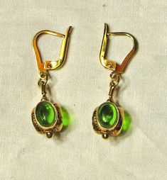 Excellent condition. Stamped 14K.  Pair weighs 5.7 grams. Total length of earrings is 1 1/2 inch, drop measures approx. 3/4 inch.  Three oval peridot cabochons on each earring that measure approx. 8 x 6.5mm. Formal Drop Cabochon Earrings, Elegant Green Cabochon Earrings, Classic Green Clip-on Earrings For Formal Occasions, Classic Green Clip-on Earrings, Formal Green Oval Cabochon Jewelry, Green Clip-on Formal Earrings, Green Clip-on Earrings For Formal Occasions, Formal Peridot Drop Earrings, Classic Green Drop Earrings