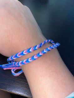 a close up of a person's wrist with two bracelets on it