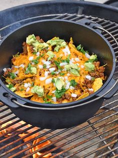 a skillet filled with taco salad sitting on top of a bbq grill