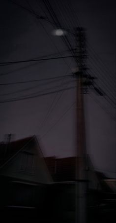 an electric pole and some houses at night