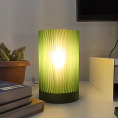 a green lamp sitting on top of a white desk