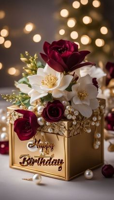 a birthday card box with flowers and pearls on the table next to a christmas tree