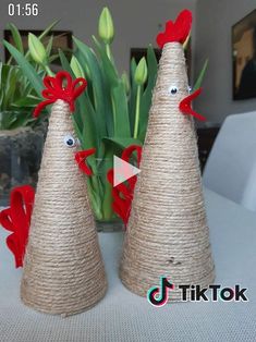 two burlap cones decorated with red bows and eyes are sitting on a table