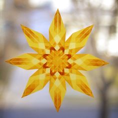 a yellow origami star hanging from a window