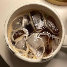 a cup filled with ice sitting on top of a table