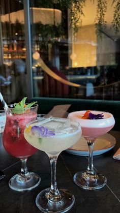 three cocktails sitting on top of a table next to each other