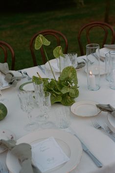 the table is set with white plates and silverware