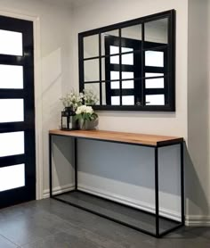 a black and white console table with flowers on it