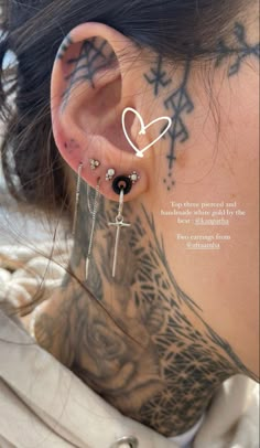 a woman with tattoos and piercings behind her ear