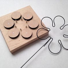 a wooden block with six circles attached to it and an electric cord connected to the board