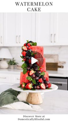 a watermelon cake with berries and strawberries on top is featured in this post