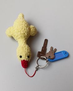 a stuffed animal keychain with two keys attached to it's sides and one has a red nose