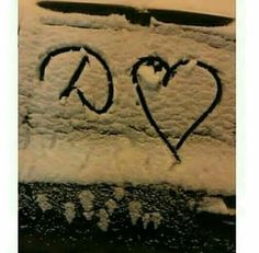 the word love is written in black ink on a snow covered surface