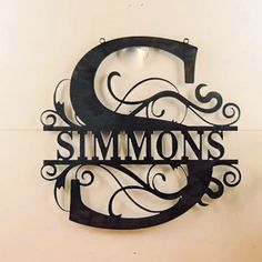 there is a metal sign that says simmonss and has swirly designs on it