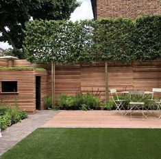 a backyard with wooden walls and green grass