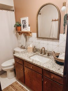 a bathroom with marble counter tops and wooden cabinets