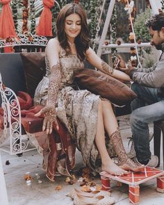 a man and woman sitting on a bench in front of an outdoor area with decorations