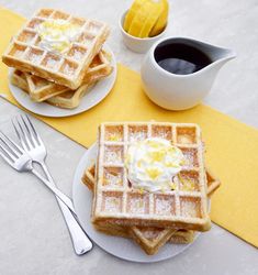 two plates with waffles and whip cream on them